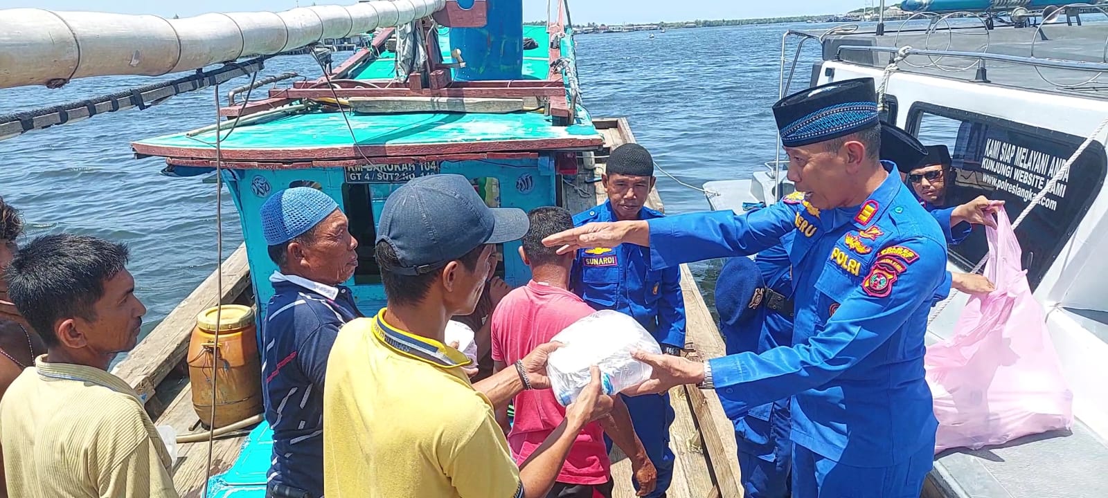 Kasat Polairud Polres Langkat AKP Heru Ediyanto SH membagikan paket takjil kepada masyarakat pesisir dan nelayan di Pangkalanbrandan, Selasa (19/3/24). Waspada/ist