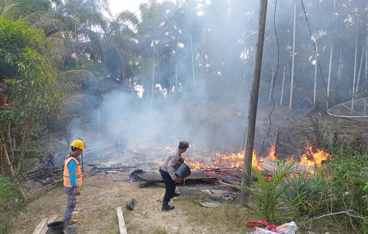 Personel Polsek Serbajadi membantu memadamkan api yang membakar rumah milik warga di Gampong Bukit Tiga, Kecamatan Peunaron, Kabupaten Aceh Timur, Selasa (12/3) sore. Waspada/Muhammad Ishak