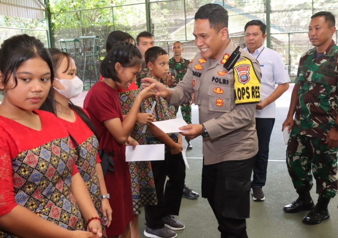 Kapolres AKBP Yogen Heroes Baruno (kanan) turut menyerahkan santunan kepada anak yatim saat syukuran HUT ke-74 Rindam I/BB di lapangan tenis indoor Rindam I/BB, Kota Pematangsiantar, Rabu (6/3).(Waspada-Ist).