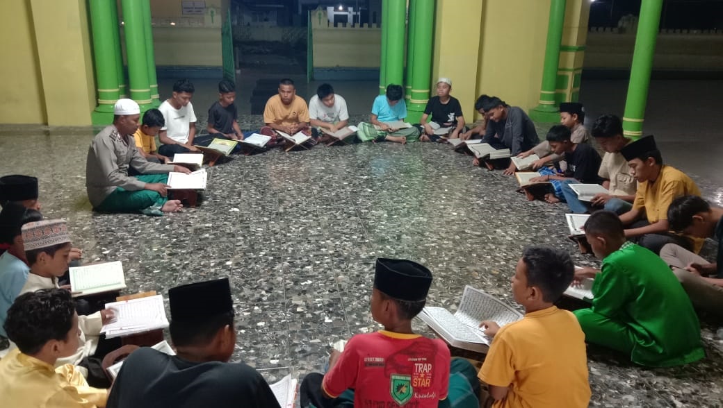 Aiptu Tantawi Jauhari, Bhabinkamtibmas dari Polsek Tanjung Pura Polres Langkat, mengajar anak-anak mengaji di Masjid Azizi, wilayah Polsek Tanjung Pura, Sabtu (16/3). Waspada/ist 