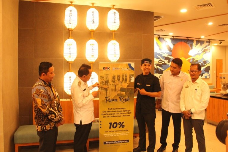 Pj Wali Kota Banda Aceh, Amiruddin, berfoto di depan tapping box yang dipasang di sebuah gerai di Suzuya Mall. (Waspada/Zafrullah)