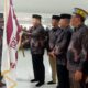 Pj Bupati Abdya Darmansah (kanan), menyerahkan bendara pataka kepada kontingen MTR Pramuka Abdya, yang akan diberangkatkan ke Banda Aceh. Kegiatan berlangsung di aula Mesjid Agung Baitul Ghafur, Blangpidie. Kamis (21/3).Waspada/Syafrizal