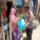 Kapolsek Kita Alam, AKP Suriya, sedang membagikan bansos berupa beras dan minyak makan kepada warga Gampong Lampulo, Banda Aceh. (Waspada/Zafrullah)