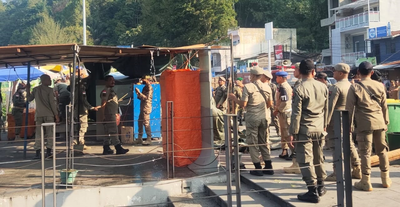 Satpol PP dan petugas kebersihan saat melakukan penertiban pedagang kaki lima dari kawasan Pantai Bebas Parapat, Senin (25/3). (Waspada/ist)