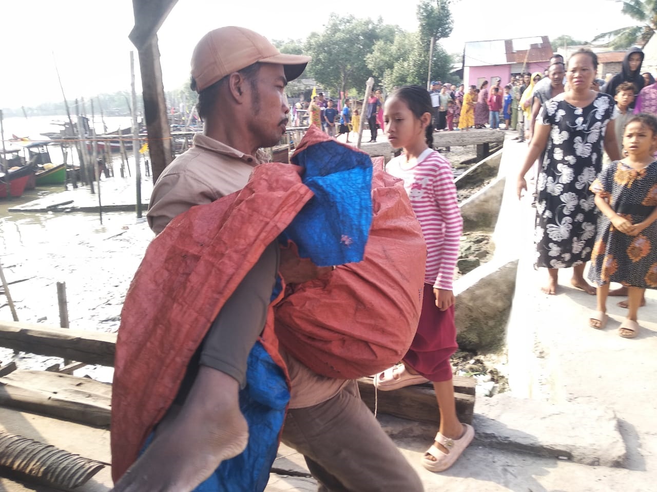 WARGA sedang membopong jenazah Rizky yang ditemukan tenggelam saat memancing di Sungai Batubara sekitar tangkahan nelayan Desa Suka Jaya, Kecamatan Tanjungtiram, Batubara. Waspada/Ist