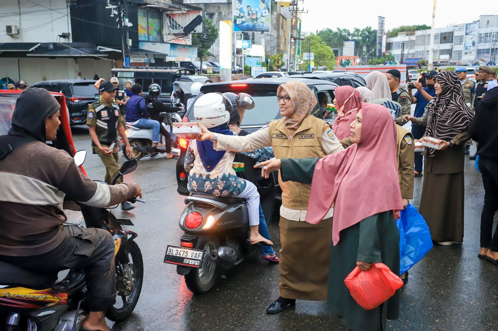 Ibu-ibu Satpol PP dan WH Kota Banda Aceh membagi-bagikan takjil kepada pengguna jalan di sekitaran Masjid Raya Baiturrahman Banda Aceh dalam rangka peringatan HUT Satpol PP, WH dan Satlinmas. (Waspada/Zafrullah)