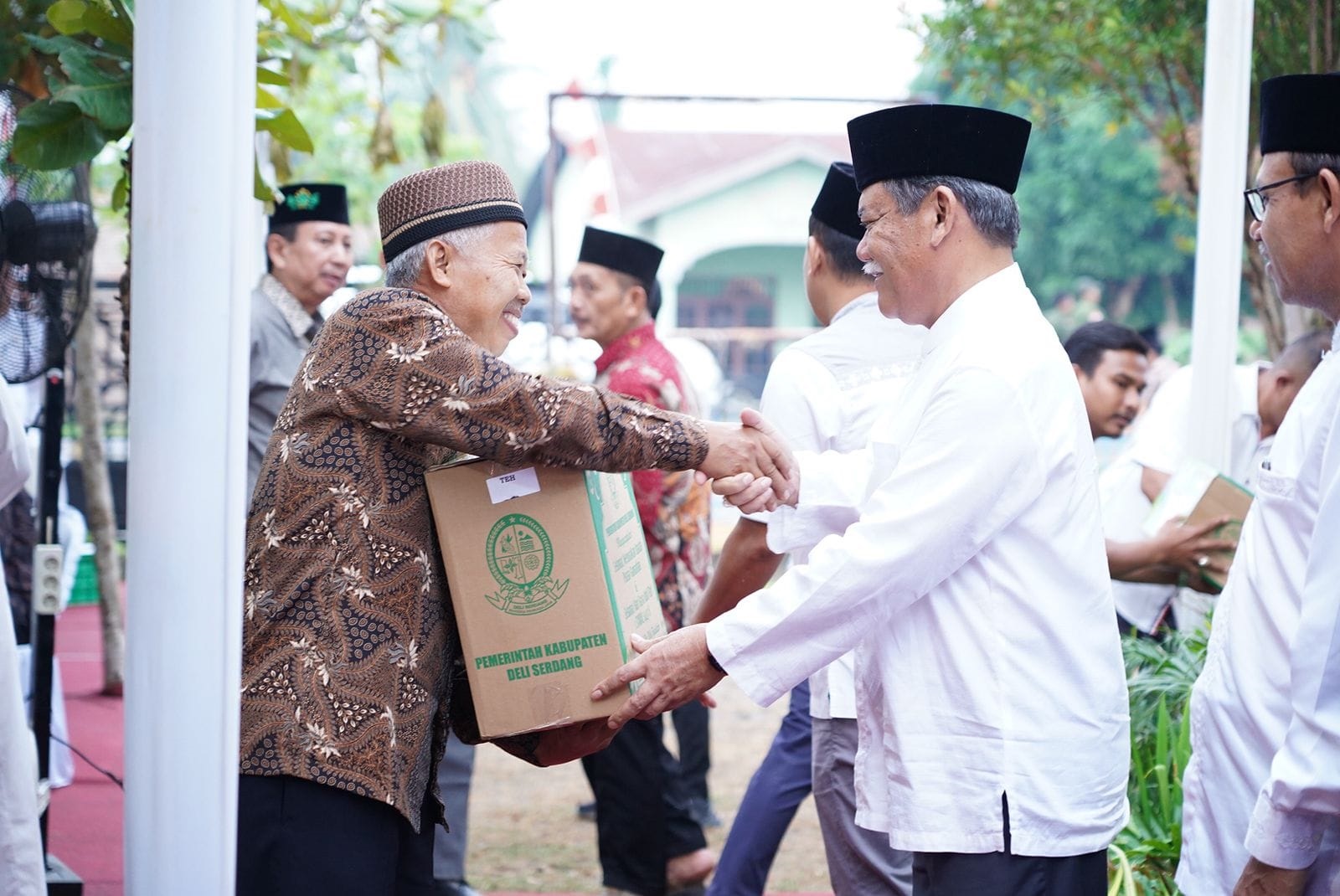 BUPATI Deliserdang HM Ali Yusuf Siregar menyerahkan bingkisan kepada Ketua BKM Baiturrahim Desa Sidodadi Kecamatan Batangkuis Ismanan pada acara Nuzulul Qur’an Pemkab Deliserdang Tahun 1445 H/2024 M dirangkai buka puasa bersama di pelataran Masjid tersebut, Rabu (27/3) sore. (Waspada/Khairul K Siregar/B)