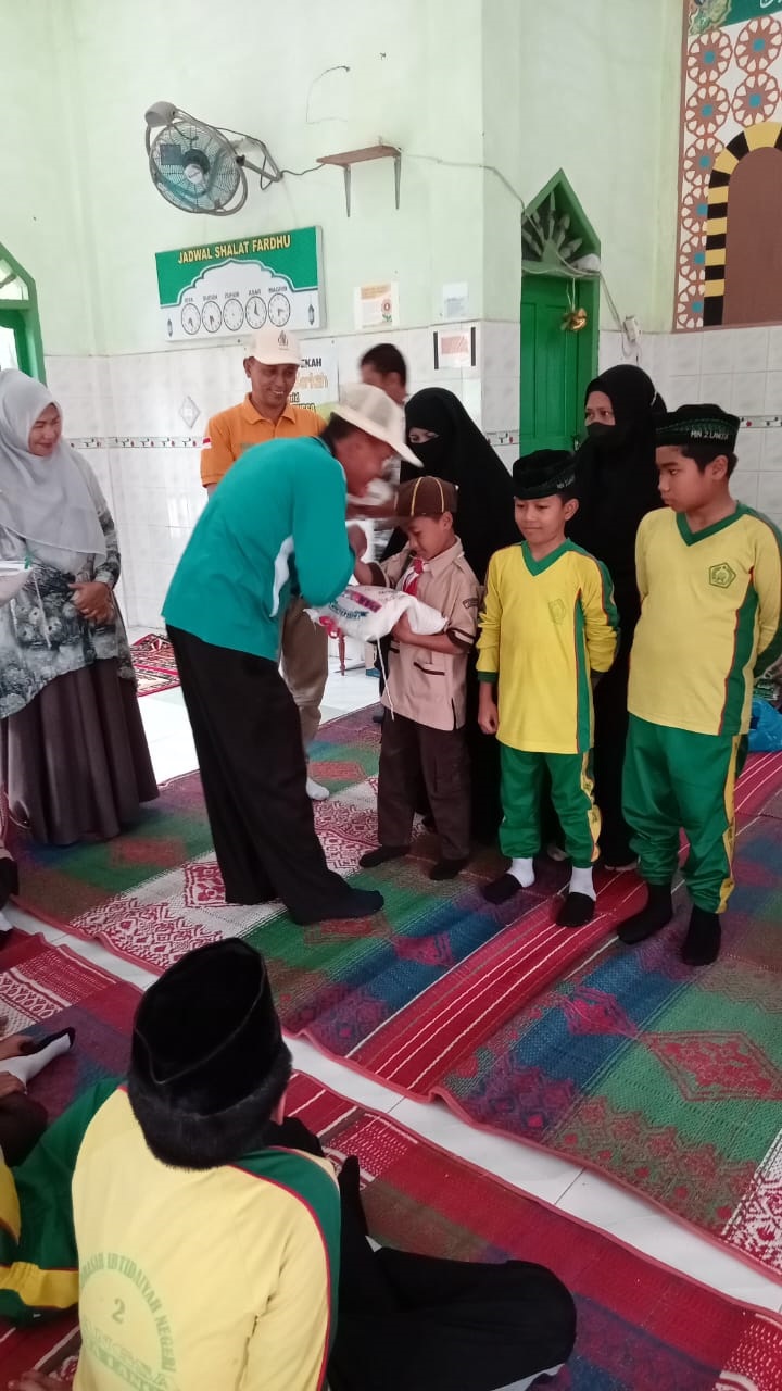 Kepala MIN 2 Langsa, Uziana, saat menyerahkan sejumlah beras kepada anak yatim, kaum dhuafa dan beberapa dayah yang ada di Kota Langsa, Jumat (8/3). Waspada/Rapian.