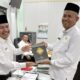 MEWAKILI PNS Katim PAI Pendidikan Menengah H.Muhammad Asrul M.Pd yang menerima Alquran dari Kabid Pakis Dr. H. Muksin Batubara, M.Pd. Waspada/ist