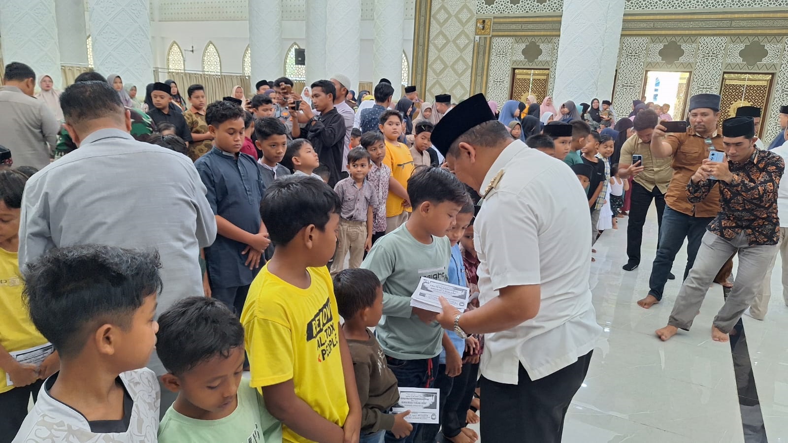 Pj Bupati Abdya Darmansah, menyerahkan santunan anak yatim yang terkumpul melalui kotak amal Masjid Agung Baitul Ghafur Abdya. Foto direkam Rabu (3/4) lalu.Waspada/Syafrizal