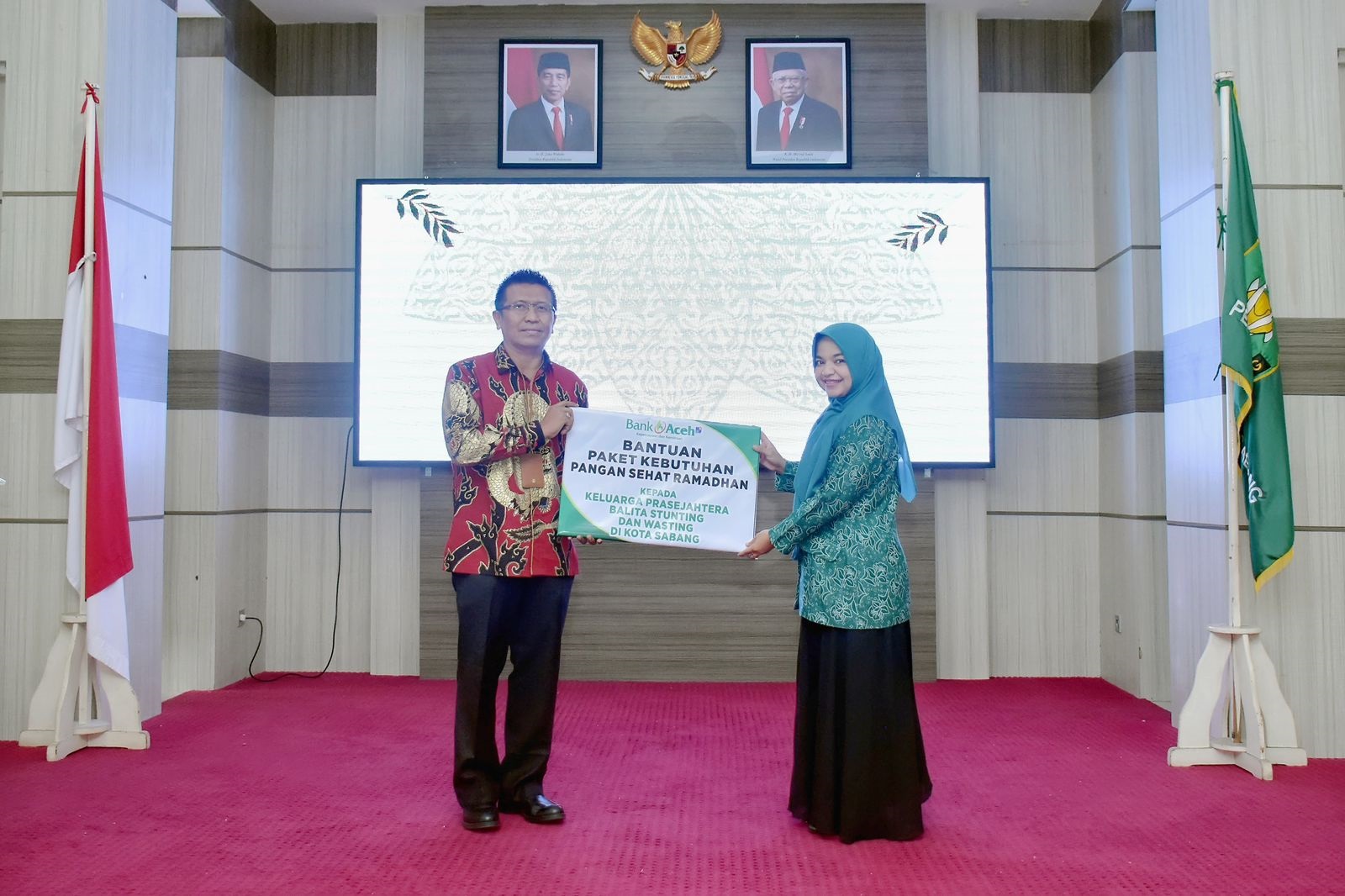 Kepala Bank Aceh Syariah Cabang Sabang, Habibie menyerahkan Bantuan Paket Kebutuhan Pangan Sehat Ramadhan secara simbolis kepada Pj. Ketua Pj Ketua TP PKK Kamelia Nasri. (Waspada/TZ)