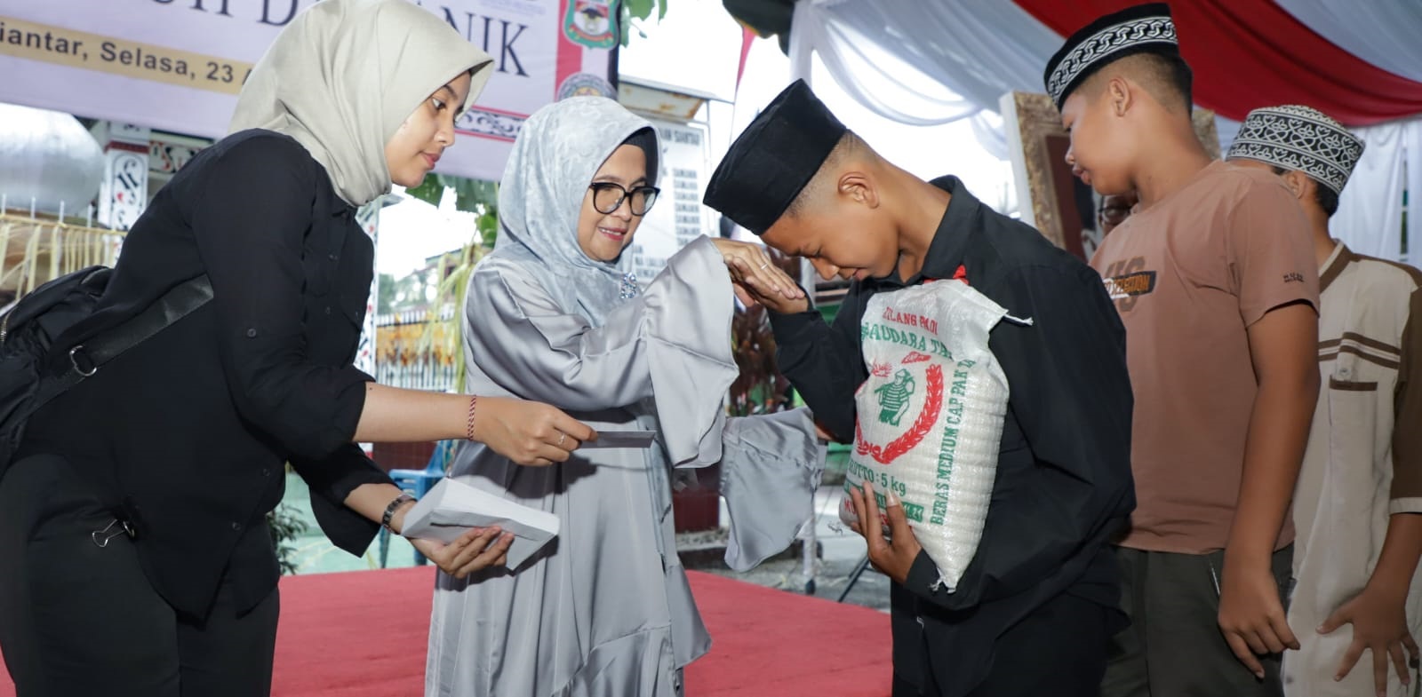 Wali Kota Susanti Dewayani (dua kiri) menyerahkan santunan kepada anak yatim dalam rangkaian peringatan Hari Jadi ke-153 Pematangsiantar dan Haul ke-110 Raja Sang Naualuh Damanik di Pesanggrahan Raja Sang Naualuh Damanik, Jl. Pamatang, Kel. Simarimbun, Kec. Siantar Selatan, Selasa (23/4).(Waspada-Ist).