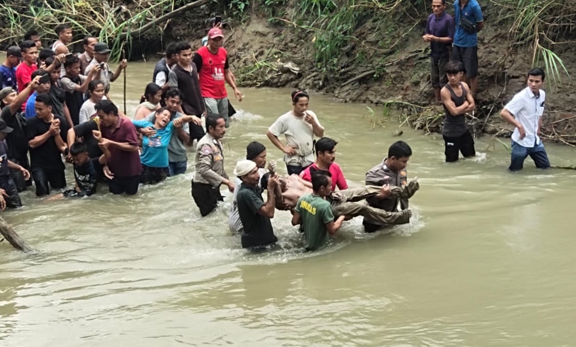 Personel Polsek Bawolato bersama warga mengevakuasi jenazah korban yang diduga terseret banjir Sungai Hou, Desa Hilifaosi, Kecamatan Bawolato, Kabupaten Nias, Rabu (24/4). Waspada/Iat