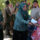 Pj Ketua TP PKK Aceh Ny Mellani Subarni Bustami didampingi Pj Ketua TP PKK Kabupaten Aceh Besar Cut Rezky Handayani memberikan bantuan kepada korban kebakaran, di Gampong Meunasah Manyang, Kecamatan Krueng Barona Jaya, Aceh Besar, Senin (22/4). (Waspada/Ist)