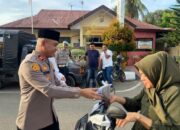 Kapolsek Lueng Bata, Iptu Rizu Fahmi ikut membagi-bagikan takjil berbuka puasa kepada pengguna jalan yang melintas di depan Mapolsek Lueng Bata. (Waspada/Zafrullah)