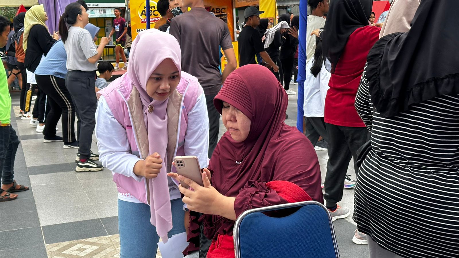 Srikandi PLN UP3 Padangsidimpuan mengajarkan cara melakukan pembayaran tagihan listrik dan pembelian token menggunakan aplikasi PLN Mobile di Alaman bolak Padang Nadimpu, Kota Padangsidimpuan, Minggu (26/5).