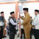 Pj Gubernur Sumatera Utara, Hasanuddin menyerahkan pataka kepada petugas kloter 01 saat acara pelepasan di Asrama Haji Embarkasi Medan. Waspada/ist