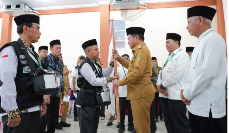 Pj Gubernur Sumatera Utara, Hasanuddin menyerahkan pataka kepada petugas kloter 01 saat acara pelepasan di Asrama Haji Embarkasi Medan. Waspada/ist