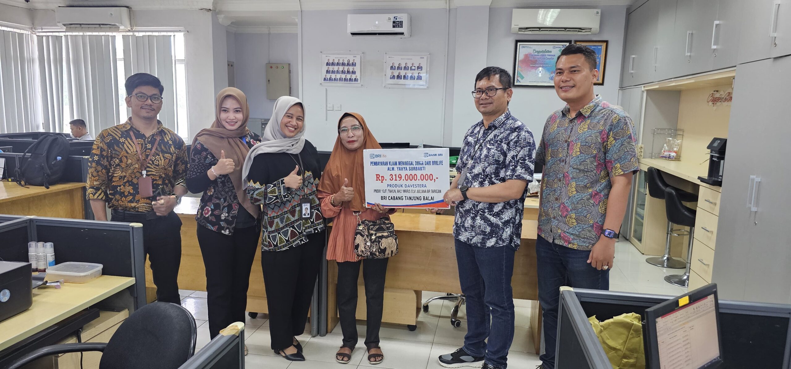 Penyerahan klaim asuransi Davestera senilai Rp319 juta kepada ahli waris Alm Yahya Surbakti, oleh Branch Office Head BRI BO Tanjungbalai, Heldin Suranta Tarigan, didampingi BFA BRILife Sutria. Waspada/Ist