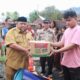 Pj Sekda Yusrizal saat menyerahkan bantuan masa panik. Waspada/Seh Muhammad Amin
