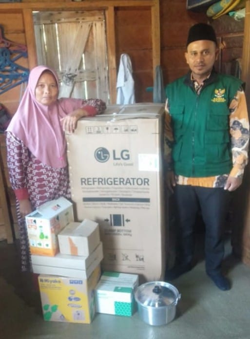 Siti Adewiyah Hasibuan, menerima bantuan modal usaha dari Baznas Palas, berupa lemari es dan peralatan masak. Waspada/Ist