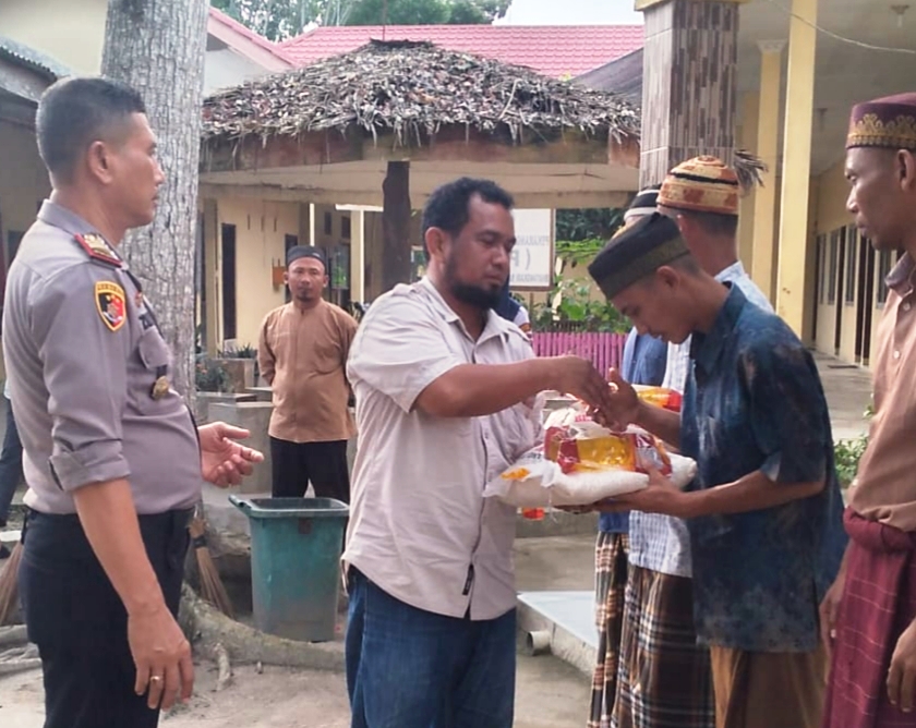 Manajer PT. Socfindo Bangun Bandar Fachry Zein didampingi Kapolsek Dolokmasihul AKP Zulham saat menyerahkan bantuan bahan pokok kepada warga binaan Polsek Dolokmasihul, Selasa (21/5) kemarin di Mapolsek di Desa Martebing. (Waspada/Ist)