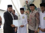 Pj Bupati Aceh Besar Muhammad Iswanto menyerahkan sertifikat kepada siswa lulusan terbaik pada acara tasyakur tahfidz angkatan III SMP Negeri 3 Al Fauzul Kabir Kota Jantho, bertempat di Halaman SMP 3 Al-Fauzul Kabir, Aceh Besar, Rabu (15/5). (Waspada/Ist)