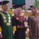 Muharrani, Penyuluh Agama PPPK Kementerian Agama (Kemenag) Kota Langsa foto bersama Rektor IAIN Langsa, Prof. Dr. Ismail Fahmi Arrauf Nasution, MA sebagai salah satu lulusan terbaik yang dinobatkan pada wisuda Institut Agama Islam Negeri (IAIN) Langsa tahun 2024, Selasa (28/5). Waspada/dede