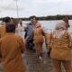 Masyarakat bersama para PNS dan pegawai honor di Kecamatan Singkil dan Kuala Baru, mendorong kendaraan yang melintas, saat menggelar aksi di jalan yang terendam banjir, Senin (20/5/2024). WASPADA/Ariefh