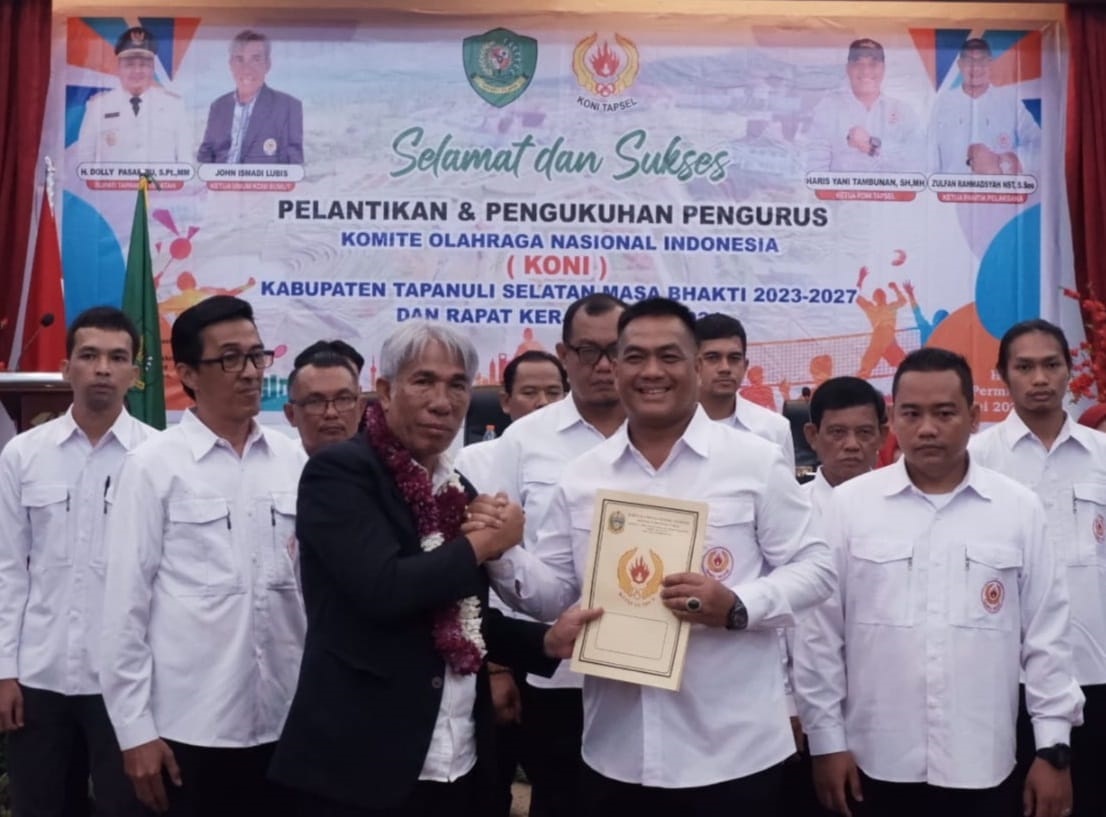 Ketua KONI Sumut John Ismadi Lubis serahkan berita acara pelantikan dan pengukuhan kepada Ketua KONI Tapsel Haris Yani Tambunan. (Waspada/Ist)