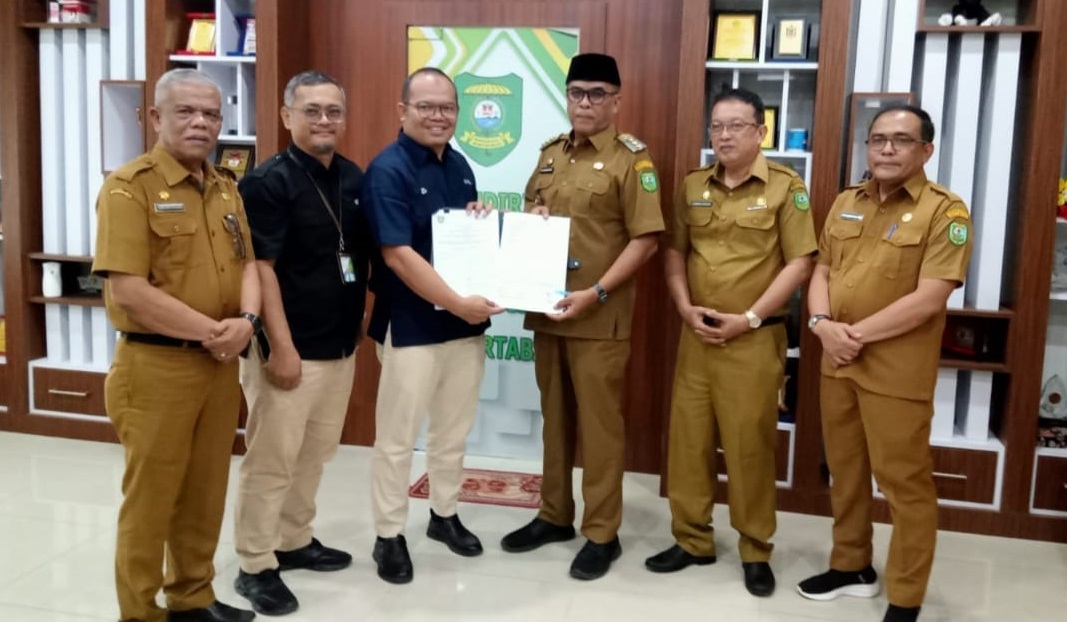 Kepala BPJS Ketenagakerjaan Cabang Padang Sidempuan, Eris Aprianto (3 kiri) didampingi Kepala BPJS Ketenagakerjaan Cabang Madailing Natal, Hadi Kurniawan (2 kiri) dan Bupati Madina HM Jakfar Sukhairi Nasution (3 kanan) tunjukkan nota keselahaman, Selasa (21/5).Waspada/ist.