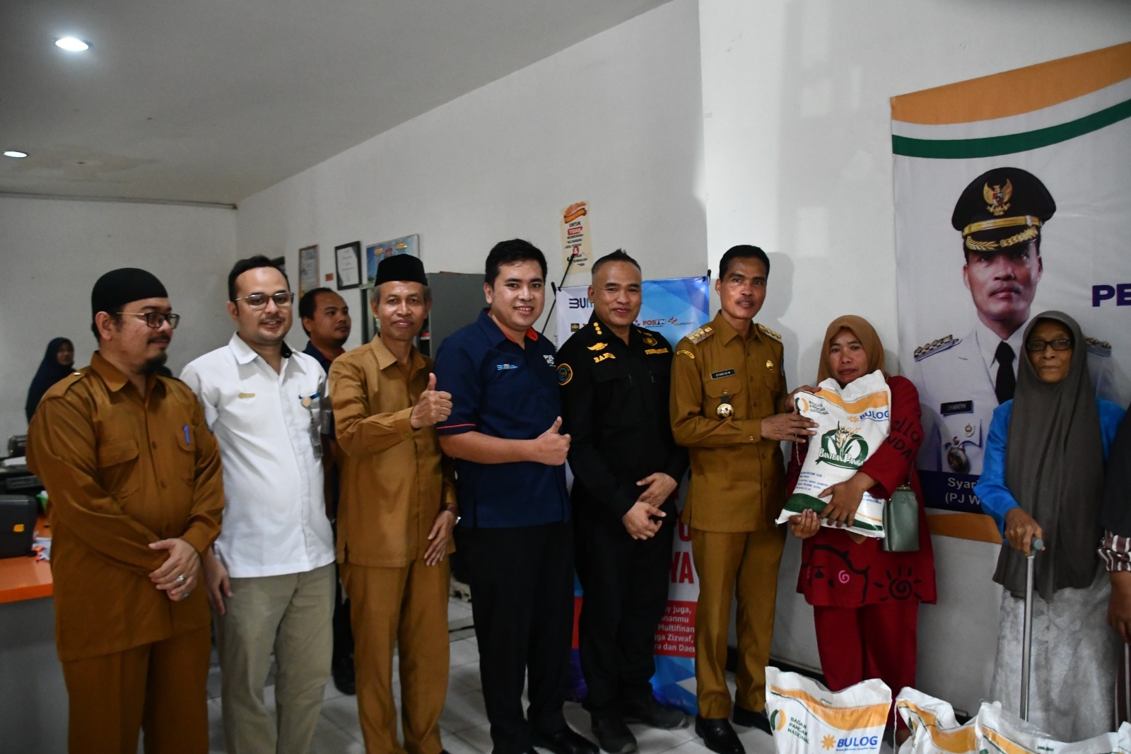 Pj Wali Kota Langsa, Syaridin, didampingi Kepala Bulog Langsa, Nasrizal Ramadhan, saat penyaluran 132 ton beras cadangan pemerintah untuk masyarakat Kota Langsa melalui Kantor Pos Langsa, Selasa (28/5). Waspada/Rapian