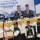 Pj.Gubernur Aceh Bustami Hamzah menyerahkan Bendera Merah Putih kepada Ketua Kloter 01 usai melepas di Aula Jeddah Asrama Haji Banda Aceh, Rabu (29/05/24).(Waspada/T.Mansursyah)