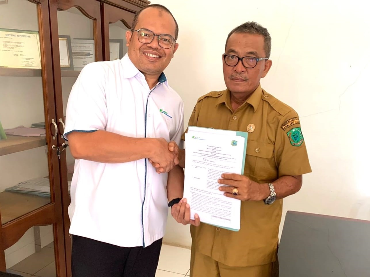 Kepala BPJS Ketenagakerjaan Cabang Padangsidimpuan, Eris Aprianto (kiri) dan Kadisnaker Paluta, Ihpan Siregar, S.Sos, MSi, tunjukkan Nota Kerjasama Pemkab Paluta dengan BPJS Ketenagakerjaan Padangsidimpuan, Selasa (7/5), Waspada/ist
