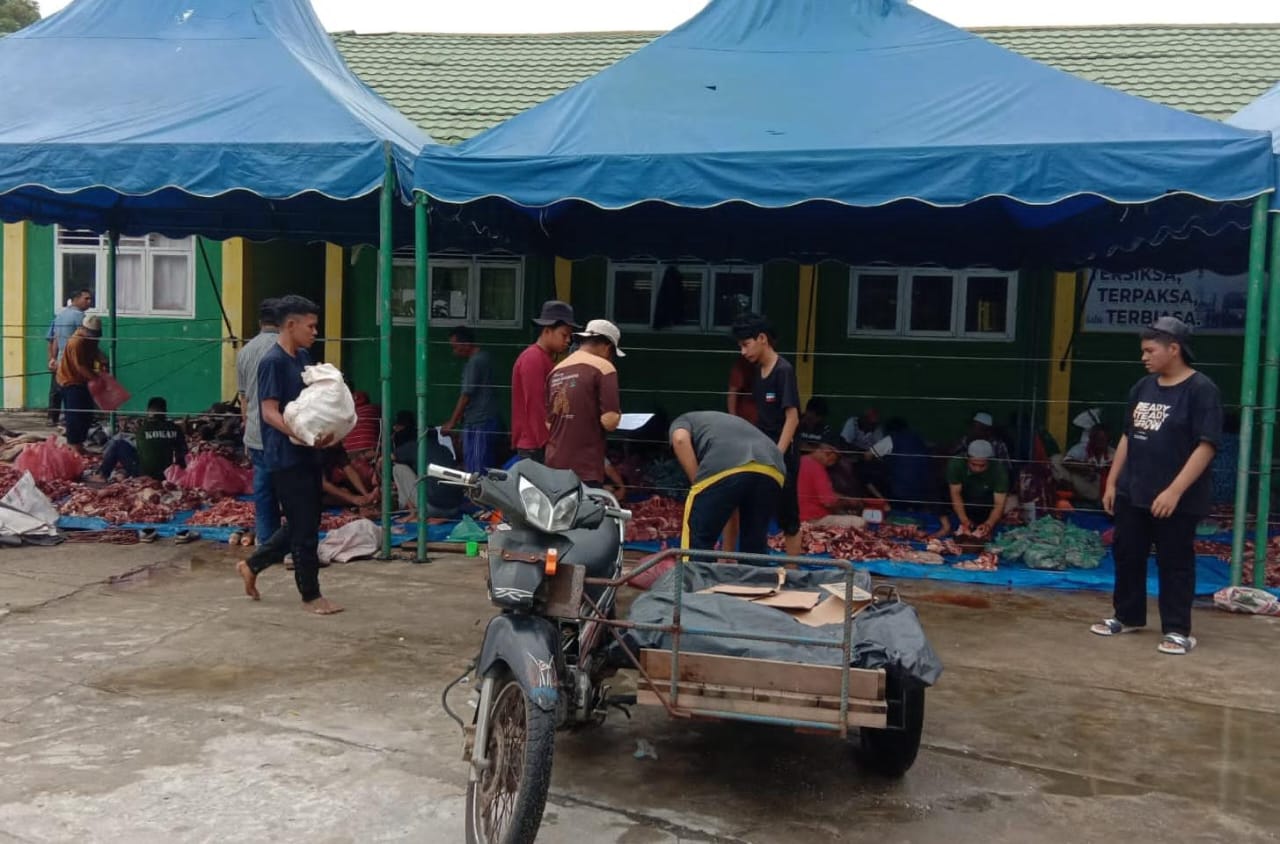 Masyarakat terlihat sibuk mengumpulkan daging yang telah dicincang untuk didistribusikan kepada masyarakat, Senin (17/6/2024). WASPADA/Ariefh