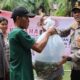 Kapolres Pematangsiantar AKBP Yogen Heroes Baruno (kanan) menyerahkan 1.000 benih ikan nila kepada warga untuk menebarkannya di kolam ikan Siantar Martoba, Rabu (19/6) siang.(Waspada-Ist).