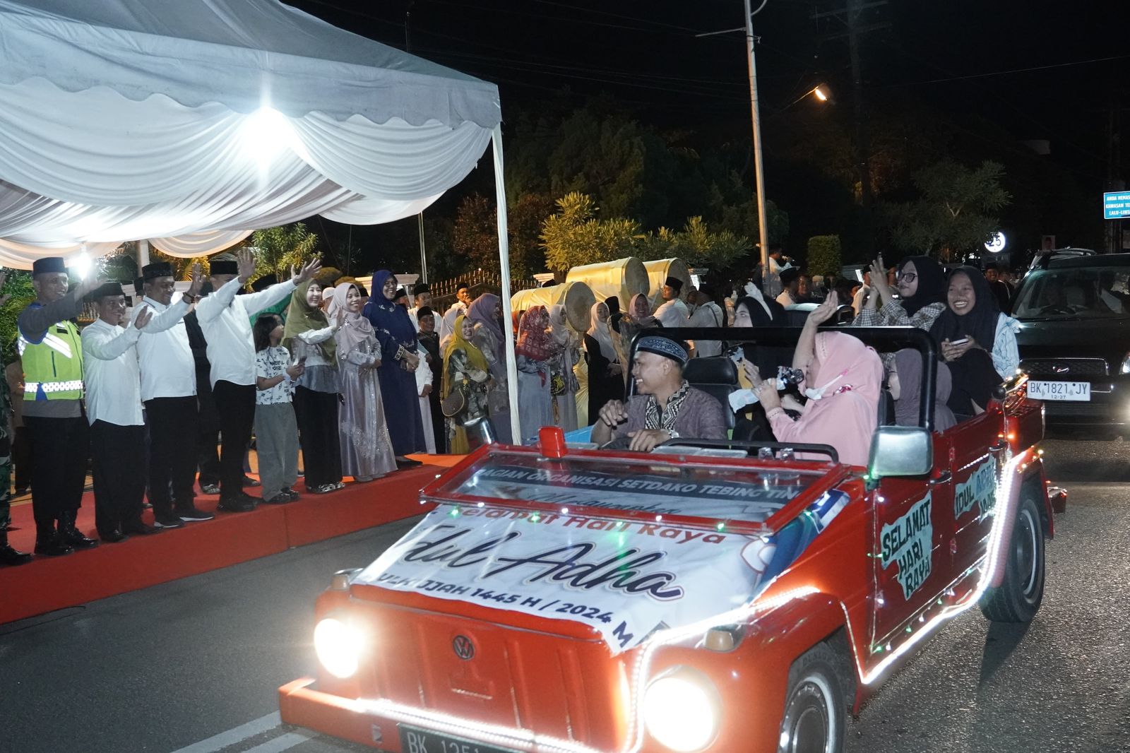 Pj Wali Kota Tebingtinggi, Dr Moettaqien Hasrimi, S.STP, M.Si didampingi Pj Ketua TP PKK Kota Tebingtinggi, dr Dara Caprina, dan para forkopimda saat menyapa iring-irangan kendaraan yang ikut pawai takbir keliling Hari Raya Idul Adha 1445 H. Waspada/Kristian Brahmana