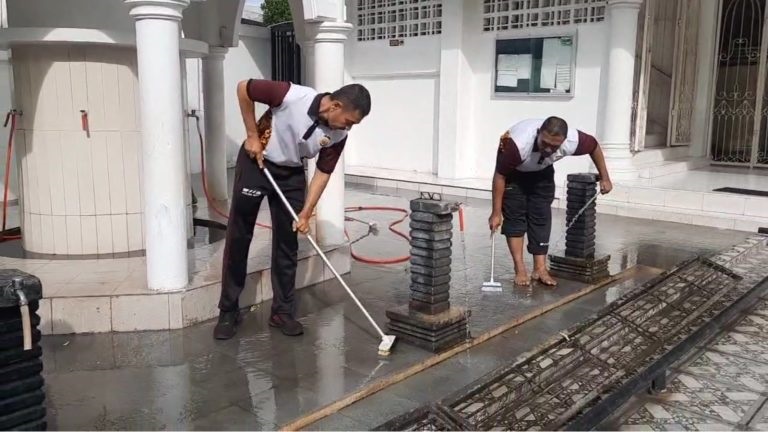 Personel Polsek Baiturrahman sedang membersihkan lantai tempat mengambil wudhu di masjid Gampong Ateuk Pahlawan, Banda Aceh. (Waspada/Ist)