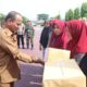 Pj Bupati Aceh Timur Ir Mahyuddin, M.Si, didampingi Kapolres Aceh Timur AKBP Nova Suryandaru SIK, menyerahkan sembako murah di Lapangan Polres Aceh Timur, Selasa (25/6). Waspada/H. Muhammad Ishak