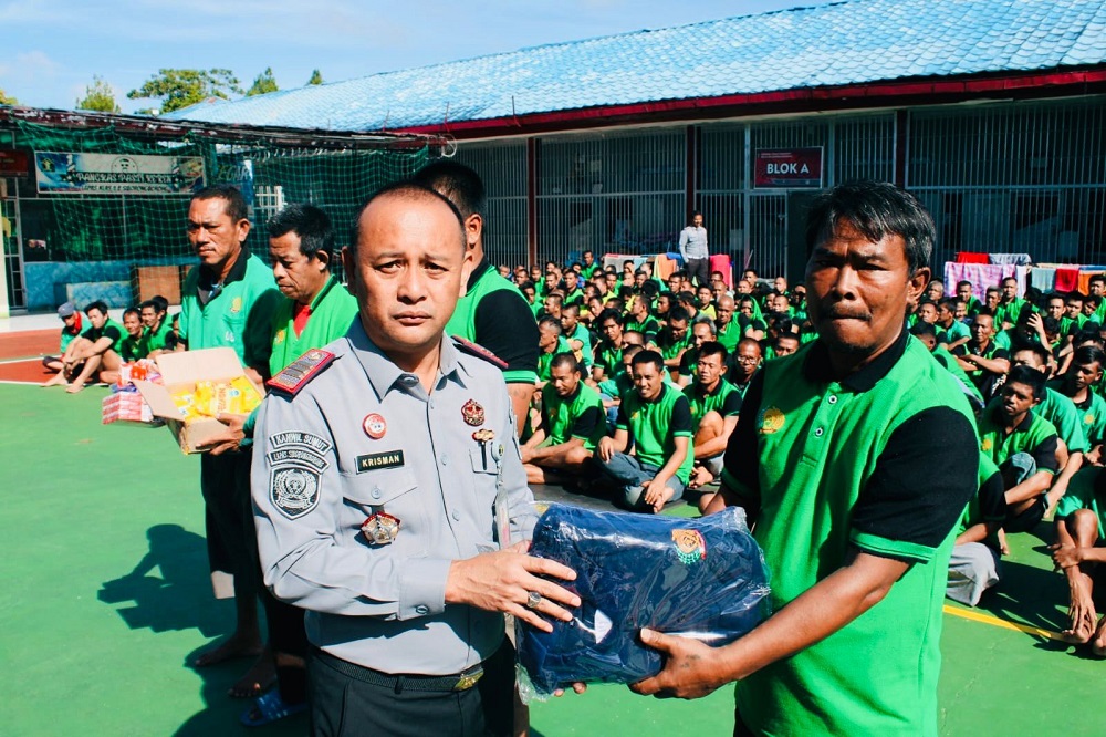 Kepala Lapas Siborongborong, Krisman Ziliwu membagikan baju seragam kepada warga binaan. Waspada/ist