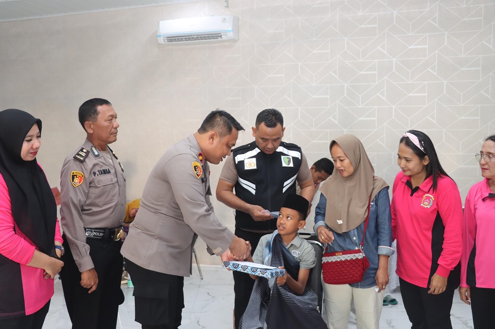 Wakapolres Batubara Kompol Imam Alriyuddin menyerahkan bantuan kepada anak yang mengikuti khitanan massal di Polres Batubara.(Waspada/Ist )