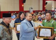 Bupati Tapanuli Selatan H Dolly Pasaribu saat meyerahkan Piagam penghargaan Kepada TPL yang diterima Manager TPL Sektor Tapsel Heddy Panjaitan.(Waspada/Ist)