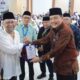 PENGHARGAAN: Kabag TU Kanwil Kemenag Sumut didampingi Sekretaris PPIH Zulfan Effendi menyerahkan penghargaan dari media peliput haji Sumut 2024 kepada pemilik bus ALS, Chandra Lubis (kiri) saat penyambutan jamaah haji Kloter 23 di Asrama Haji Medan, Minggu (21/7) dinihari. Waspada/Surya Efendi