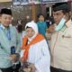 Hj. Jenni Heriyani diapit Sekretaris PPIH Embarkasi Medan Zulfan Effendi (kiri) dan Pimpinan KBIH Babussalam Medan, Ardy Chaniago (kanan) di Asrama Haji Medan, Jumat (12/7) dinihari. Waspada/Surya Efendi