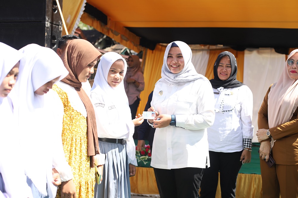 Wakil Bupati Madina, Atika Nasution saat memberikan buku yasin kepada pengajian, dan KTP kepada pemilih pemula secara simbolis di Desa Sikapas. (Waspada/ist).