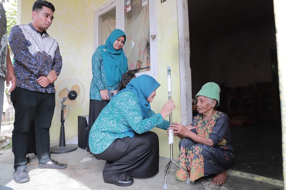 Pj Ketua TP PKK Aceh Besar Cut Rezky Handayani didampingi Pelaksana Tugas (Plt) Kepala Dinas Sosial Aceh Besar Aulia Rahman dan Camat Blang Kota Jantho Azhar menyerahkan bantuan alat bantu jalan untuk 5 lansia di Gampong Teureubeh, Kota Jantho, Kamis (4/7). (Waspada/Ist)
