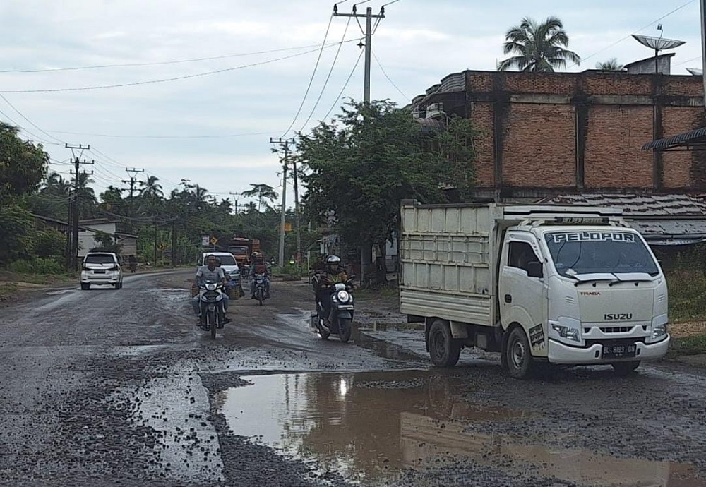 Berbagai jenis kendaraan ekstra hati-hari melintasi jalan negara yang terhenti perbaikan di Jalinsum Banda Aceh - Medan, Gampong Alue Bu Jalan, Peureulak Barat, Aceh Timur, Minggu (7/7). Waspada/H. Muhammad Ishak