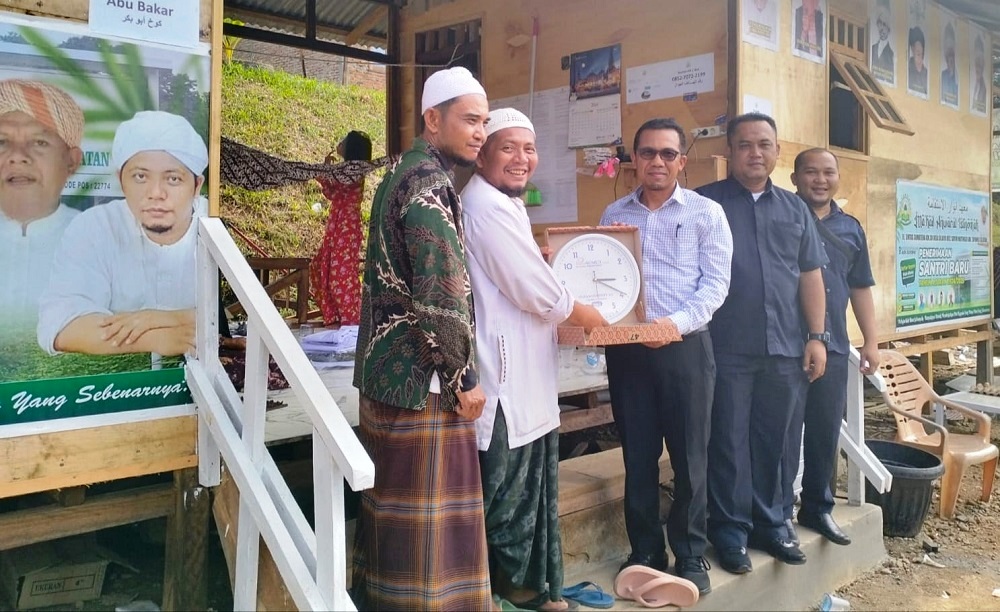 Pimpinan Cabang Bank Sumut Syariah Padangsidimpuan, Hilman Saleh Daulay (kanan) memberikan jam dinding kepada Pimpinan Ponpes Ma'had Anwarul Istiqomah ustadz Alfaqir H Zainuddin Arifin Nasution, M.Pd, Selasa (9/7). Waspada/ist.