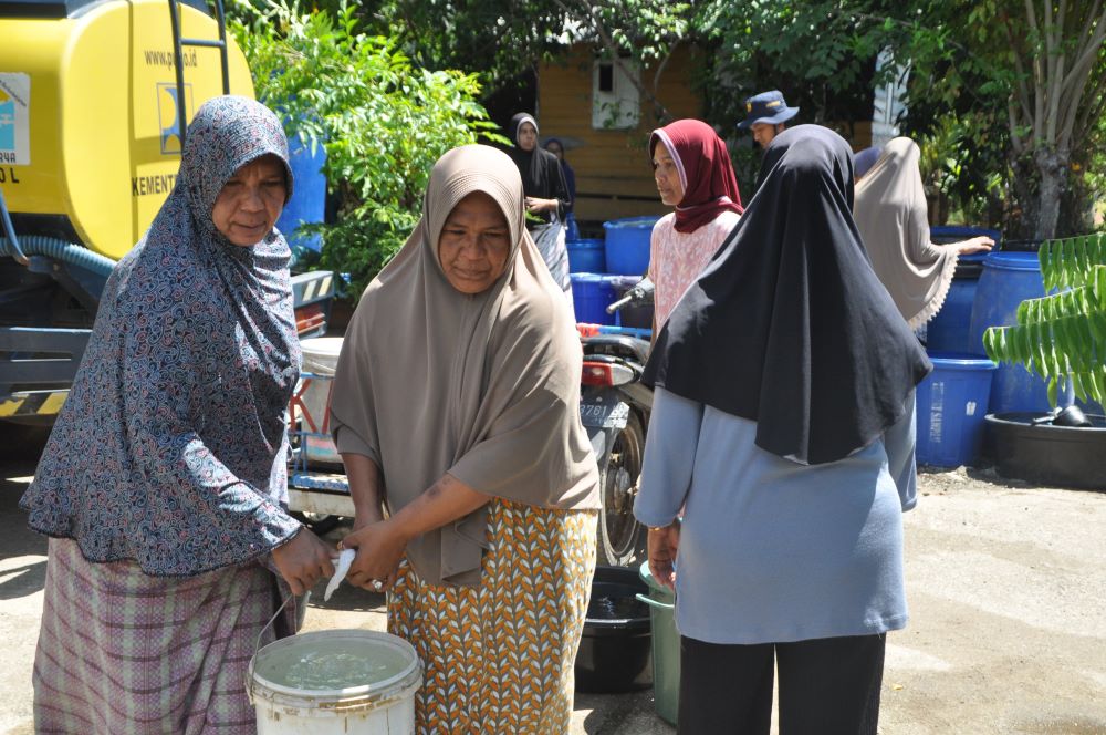 Masyarakat mengambil air bersih yang disalurkan oleh BPBD Aceh Besar, BPPW Aceh dan PDAM Tirta Mountala Aceh Besar, di Gampong Lamcok, Kecamatan Lhoknga, Kabupaten Aceh Besar, Selasa (9/7). (Waspada/Ist)