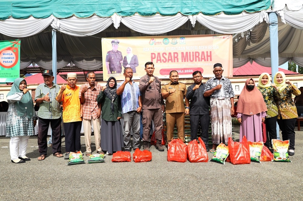 Pj Bupati Aceh Besar Muhammad Iswanto menyerahkan secara simbolis belanja kepada warga saat membuka pasar murah dalam rangka bakti sosial Kejaksaan Negeri Aceh Besar menyambut Hari Bhakti Adhyaksa ke-64 tahun 2024 di komplek Kejaksaan Negeri Aceh Besar, di Kota Jantho, Kamis (11/7). (Waspada/Ist)